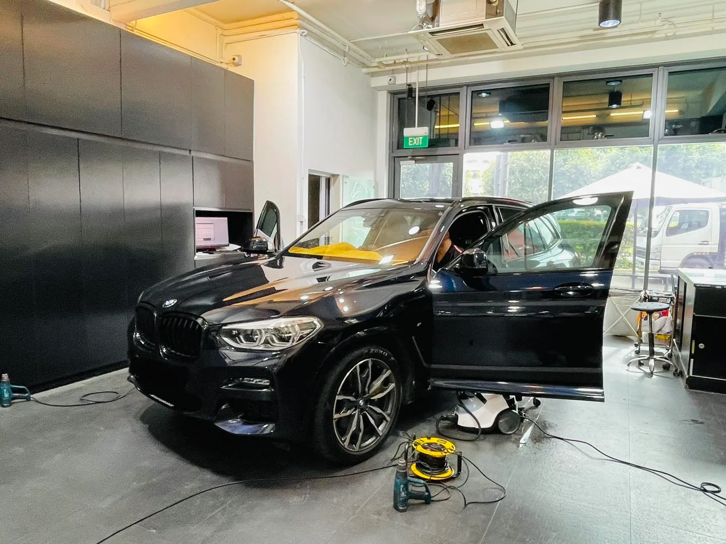 Black BMW X3 SUV during window film installation at Infratint Singapore