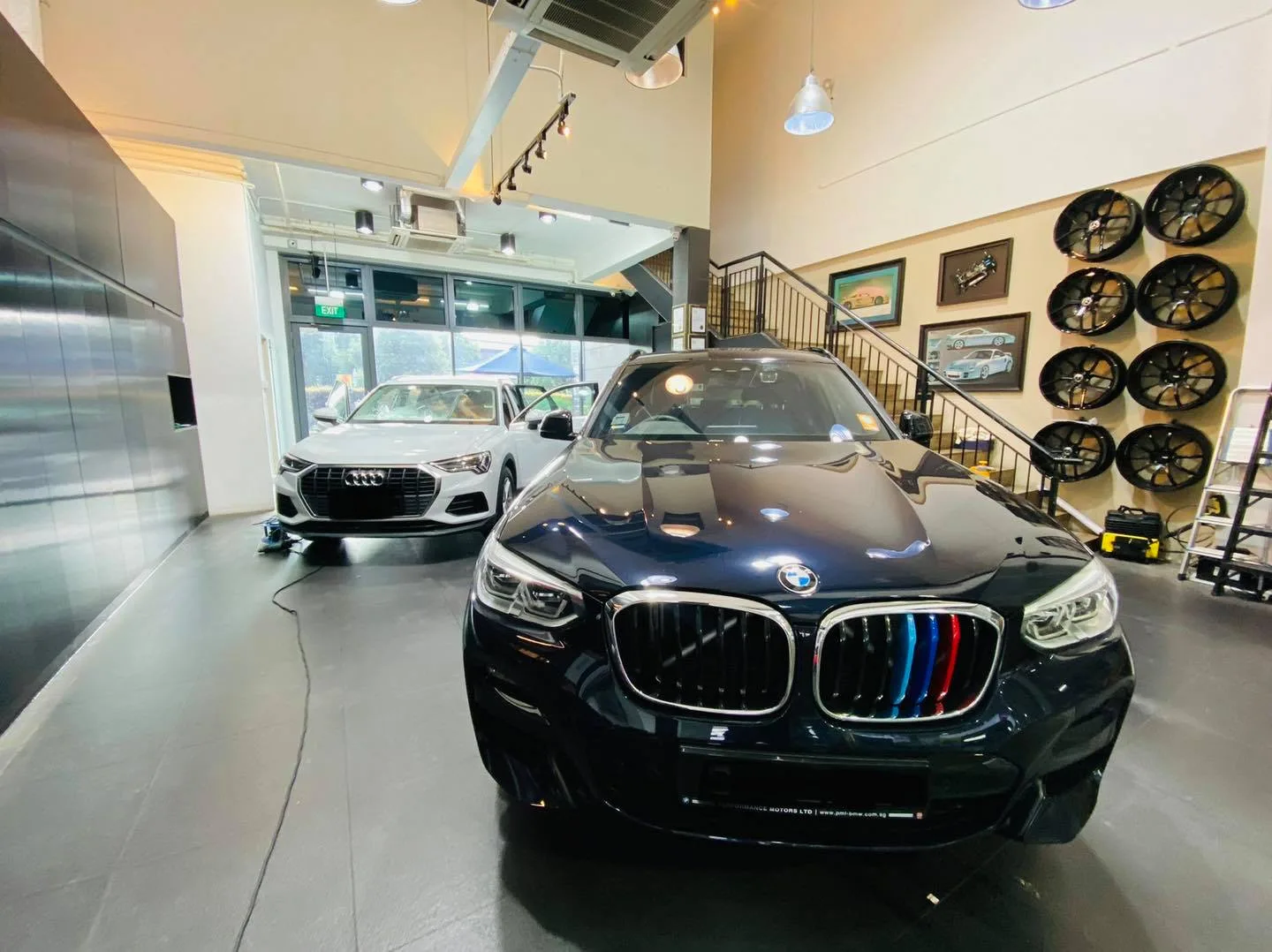 Dark blue BMW X3 and white Audi Q3 inside the Infratint Singapore showroom for window tinting