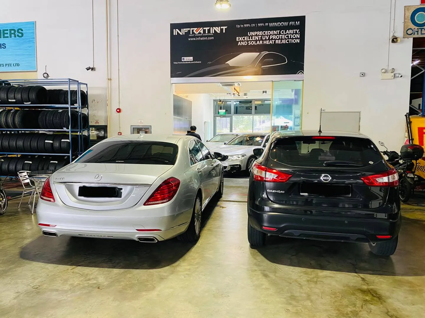 Silver Mercedes-Benz S-Class and black Nissan Qashqai under the Infratint banner at Infratint Singapore