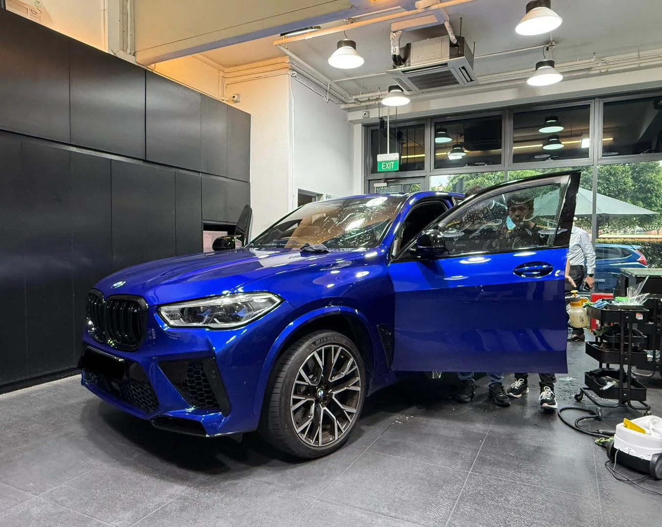 Blue BMW X5 M front three-quarter inside Infratint Singapore workshop during Platinum99 install