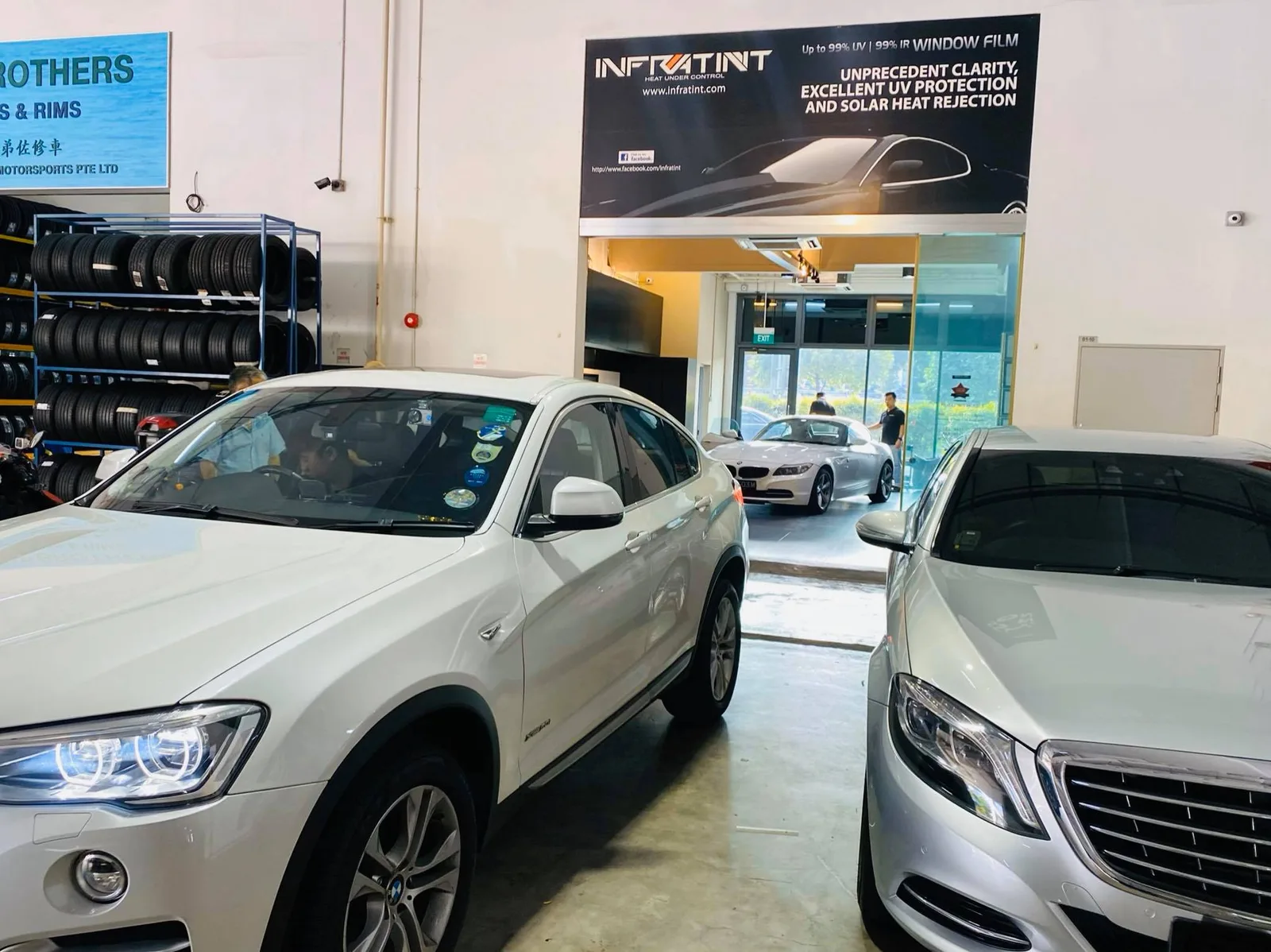 White BMW X4 and silver Mercedes-Benz sedan in the install bay at Infratint Singapore
