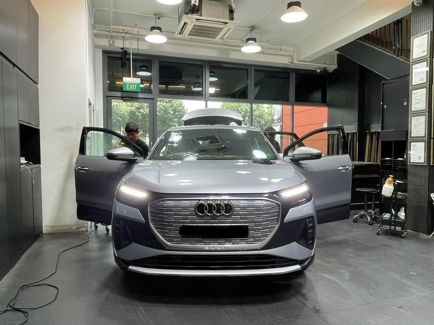 Silver Audi Q4 Sportback e-tron with front doors open inside the Infratint workshop