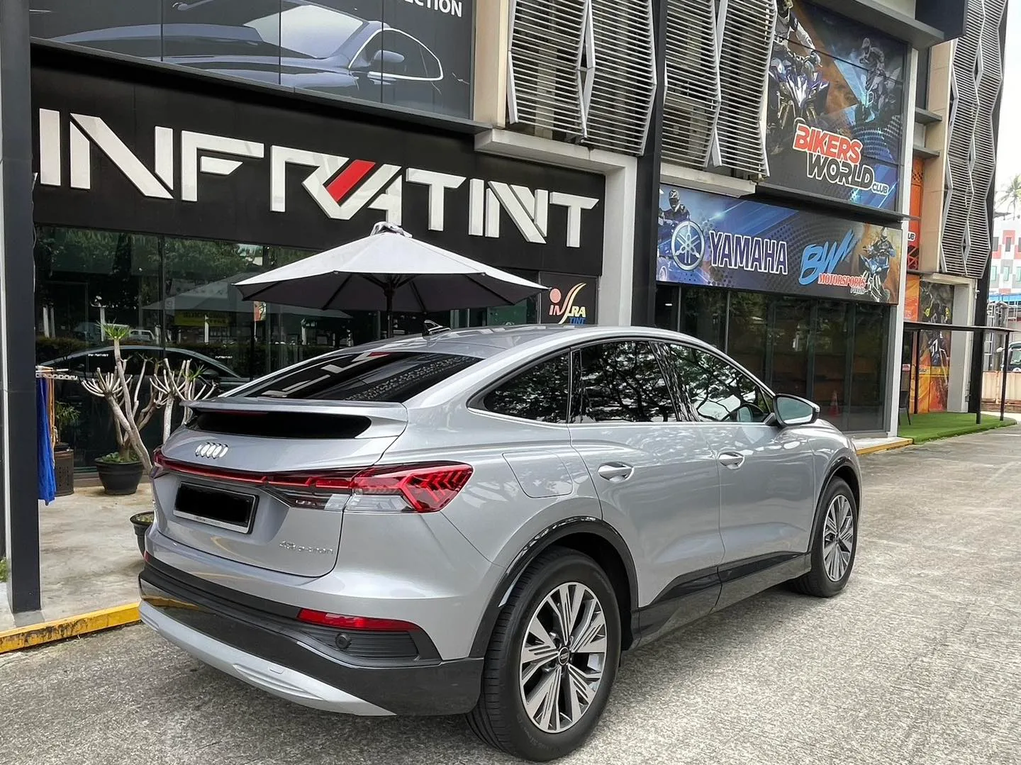 Silver Audi Q4 Sportback e-tron rear three-quarter view outside Infratint Singapore