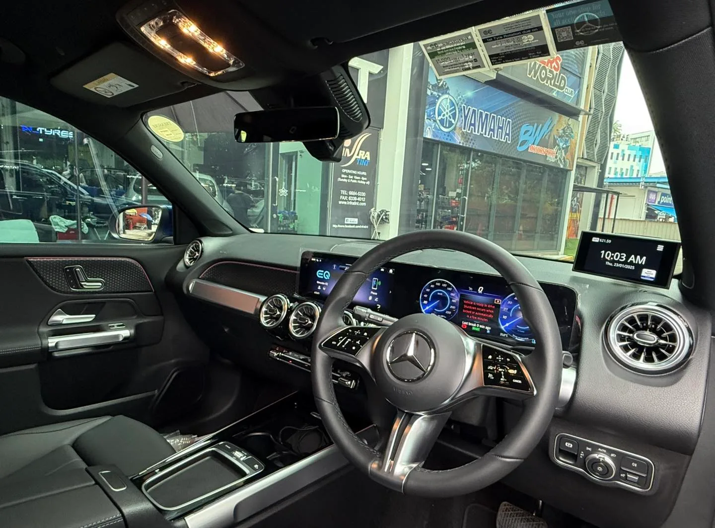 Mercedes-Benz EQB interior steering wheel and displays seen through tinted glass at Infratint Singapore