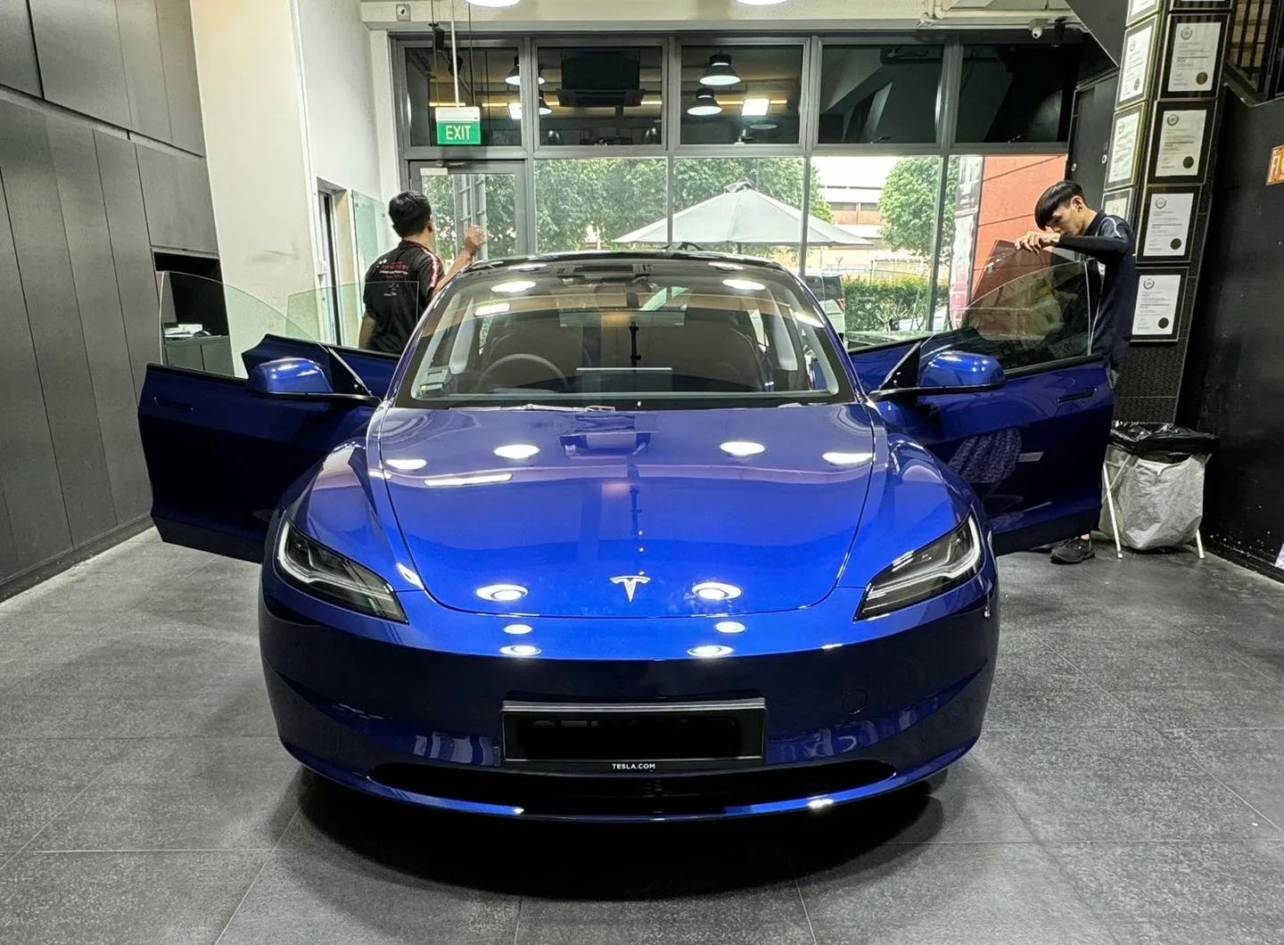 Blue Tesla M3H front view inside Infratint Singapore workshop during film install