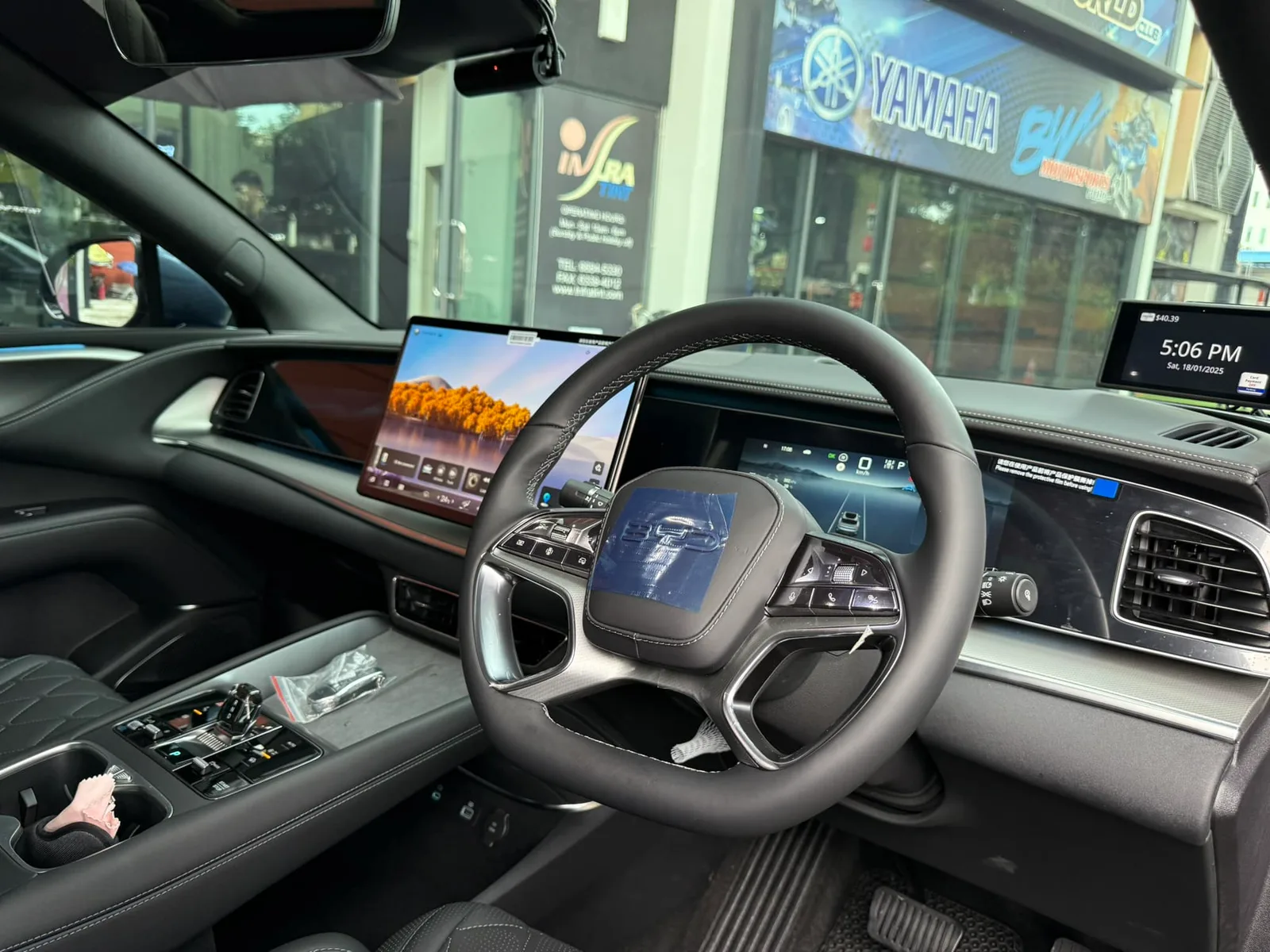 BYD Sealion 7 interior with dual screens seen through tinted glass at Infratint Singapore