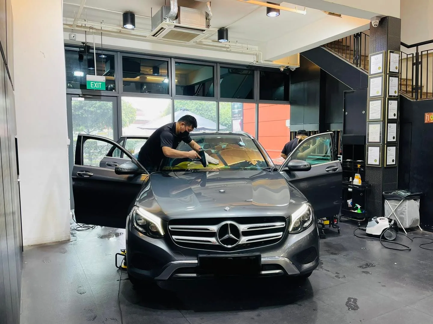 Technician tinting the windscreen of a grey Mercedes-Benz GLC at Infratint Singapore