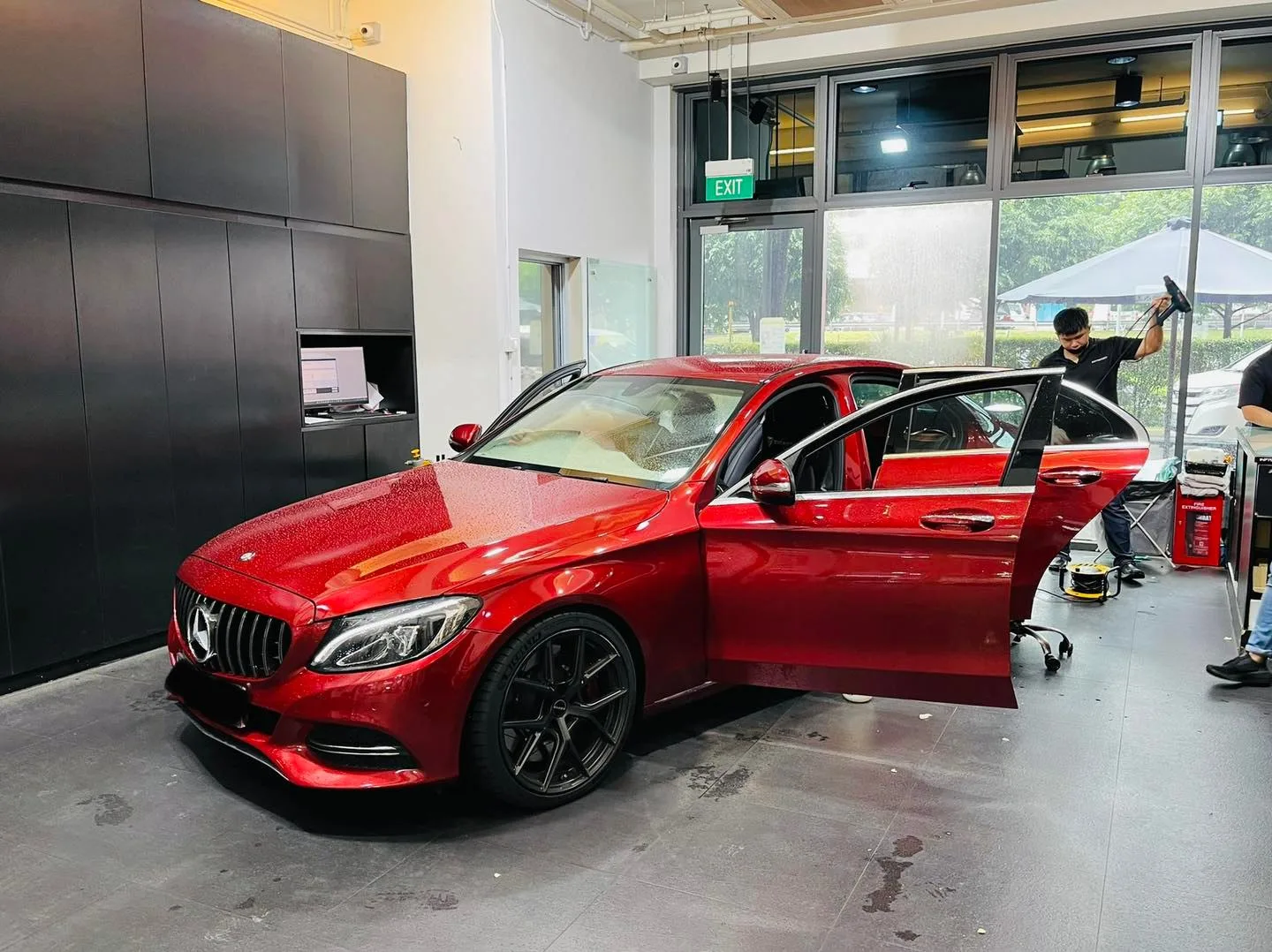 Installer tinting a red Mercedes-Benz C-Class side window at Infratint Singapore