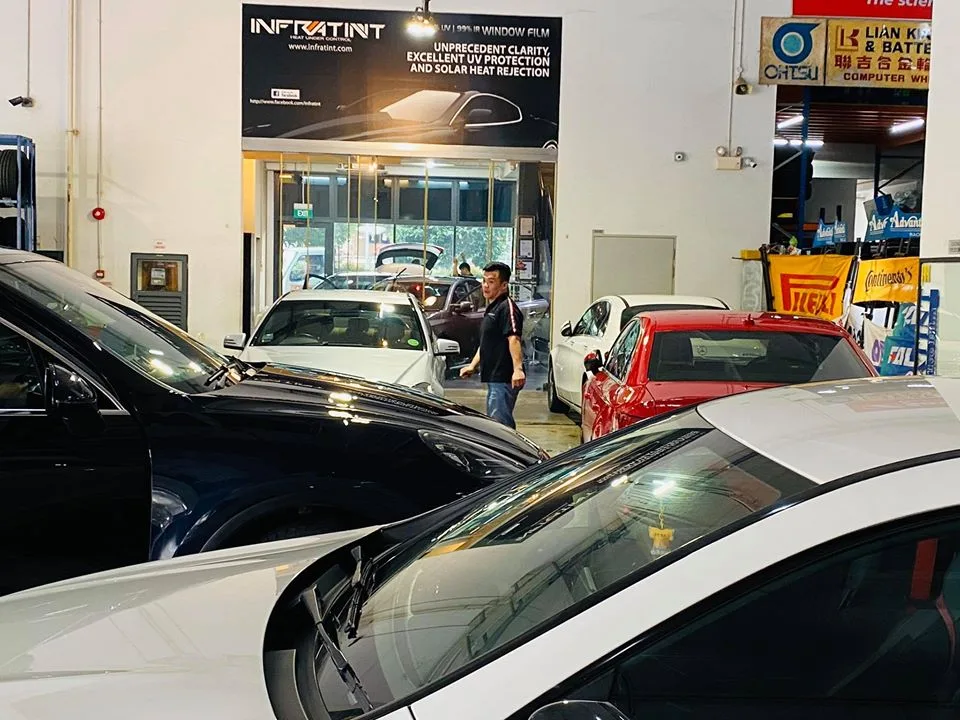 Several cars waiting for window tinting inside the busy Infratint Singapore install bay