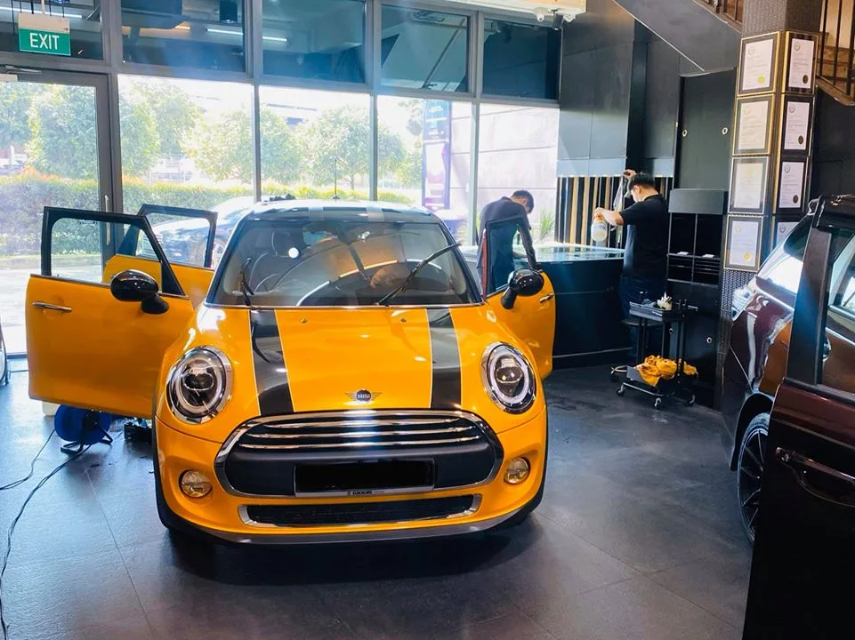 Orange Mini Cooper with doors open being prepared for window tinting at Infratint Singapore