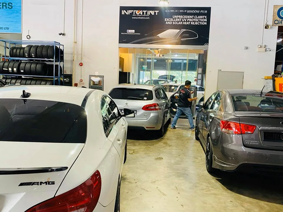 White Mercedes-Benz AMG, silver Peugeot 308 and grey Kia Forte parked inside Infratint Singapore