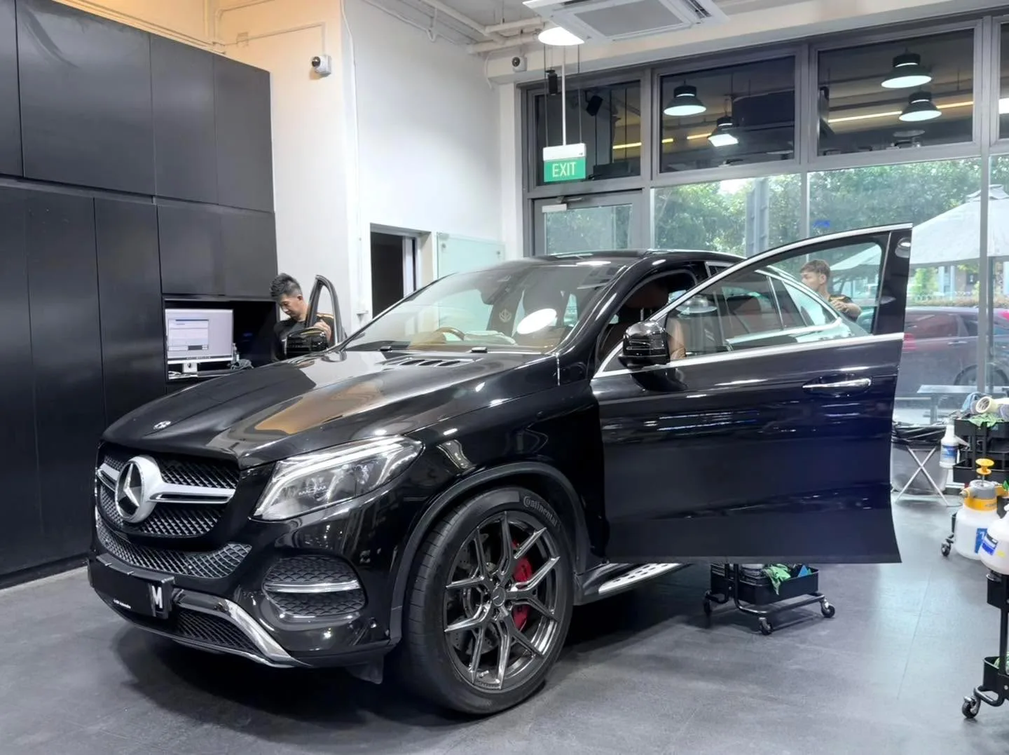Black Mercedes-Benz GLE SUV during tinting work indoors.