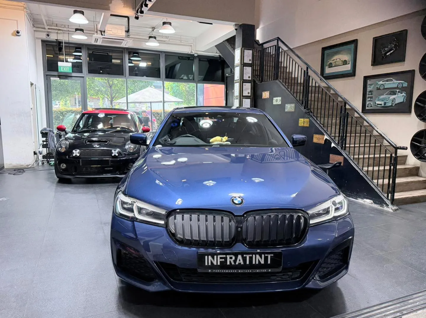 A blue BMW 520 saloon parked indoors, facing the camera.
