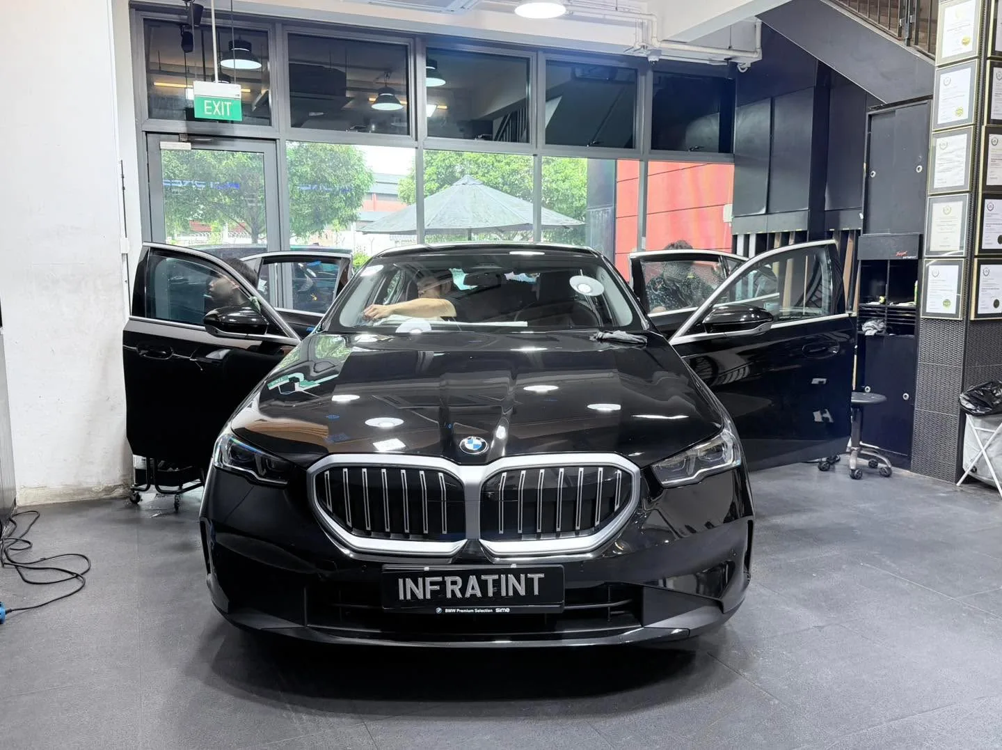 A grey Tesla sedan and a black Tesla sedan parked indoors.