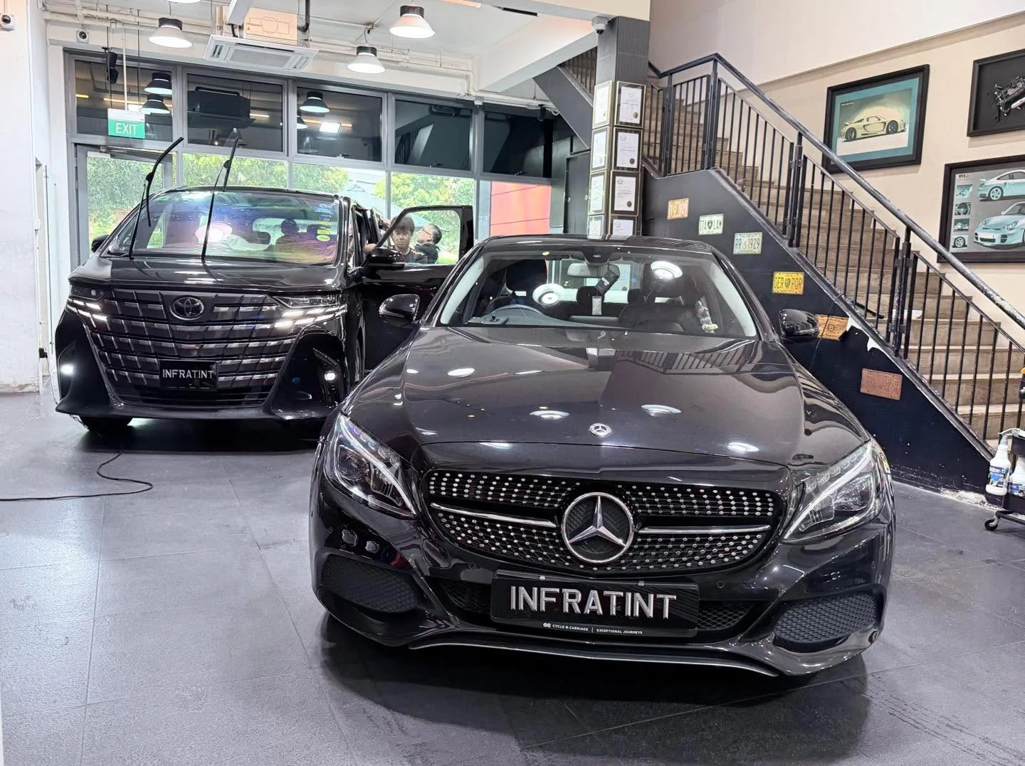 A black Mercedes-Benz C-Class sedan with its distinctive grille, parked indoors.