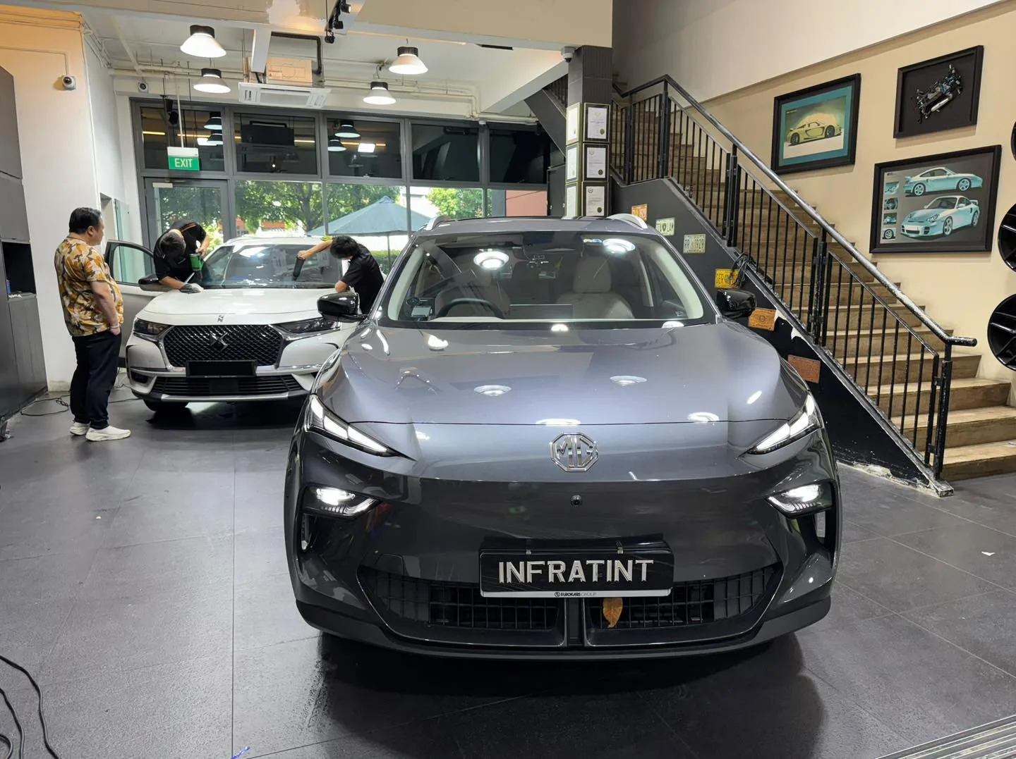 A white BMW sedan and white Citroen DS7 SUV in the workshop.