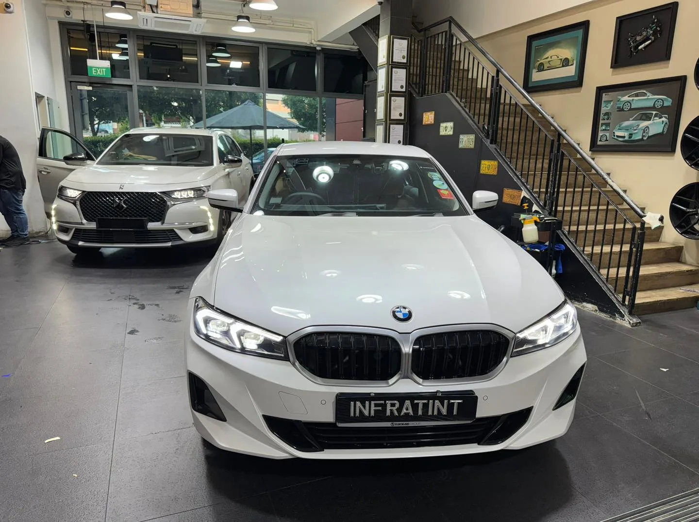 A white BMW sedan parked facing forward in the facility.
