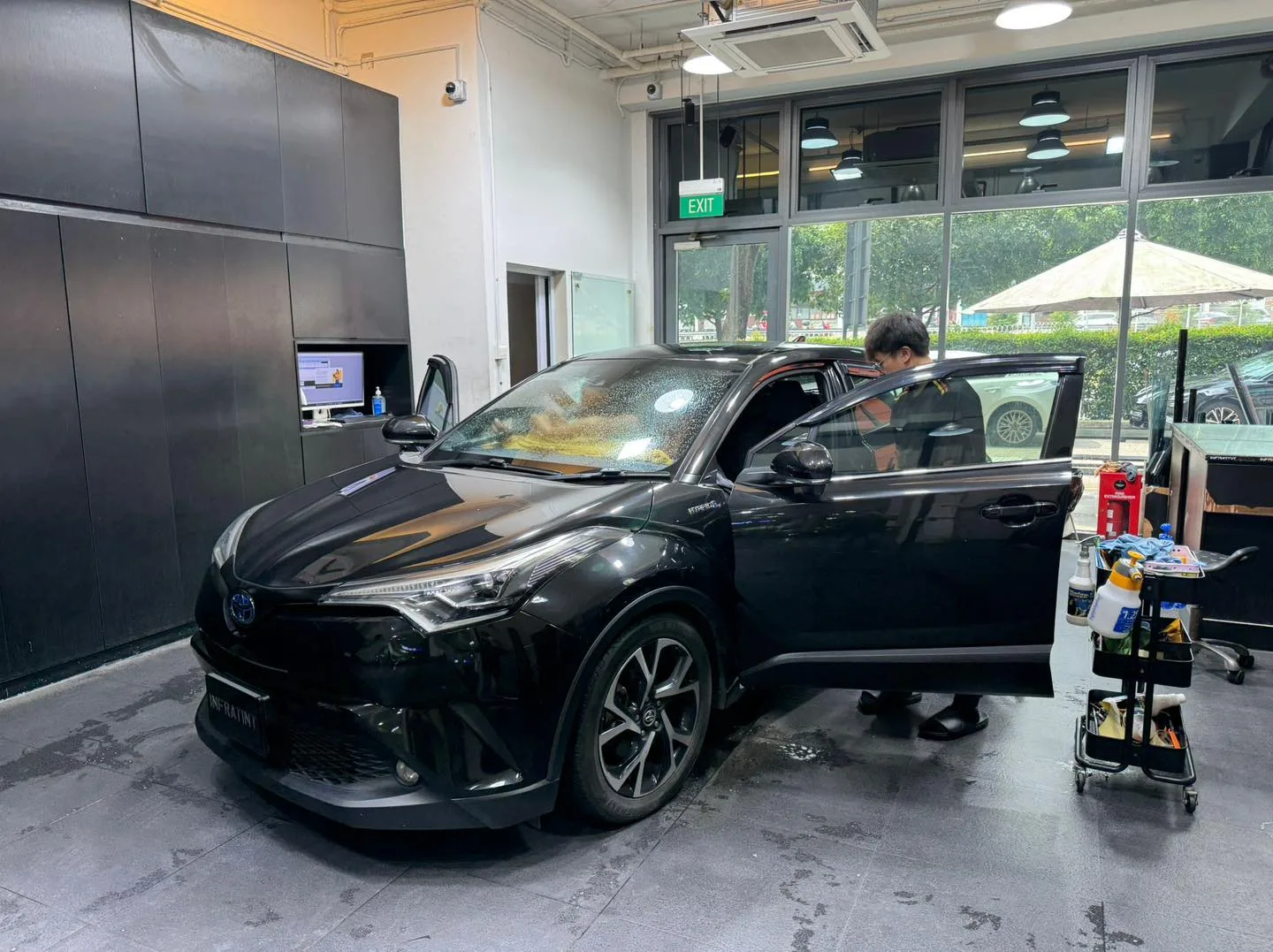 A black BYD Sealion 7 crossover with its door open inside the workshop.