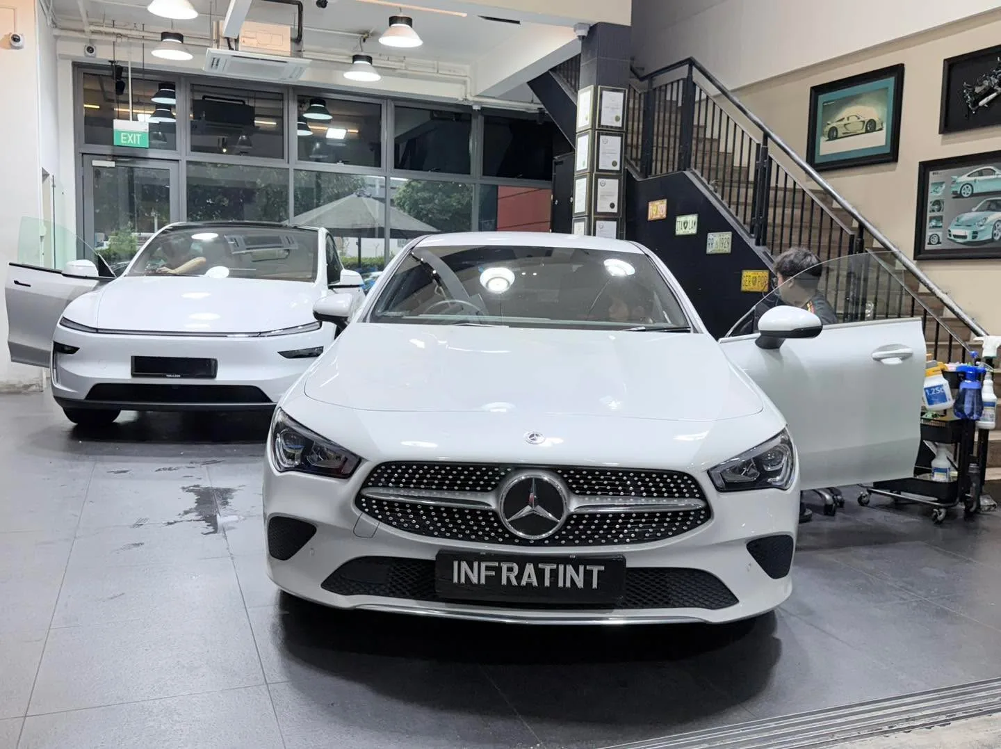 A white Subaru Levorg wagon with doors open in the workshop.
