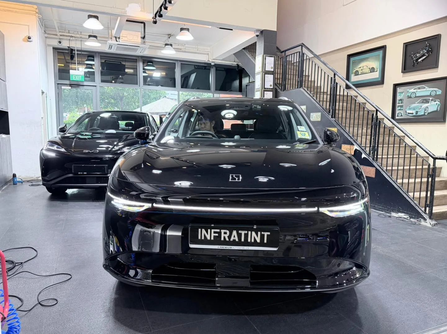 A black Zeekr electric sedan parked in an interior space with another black vehicle visible behind it.