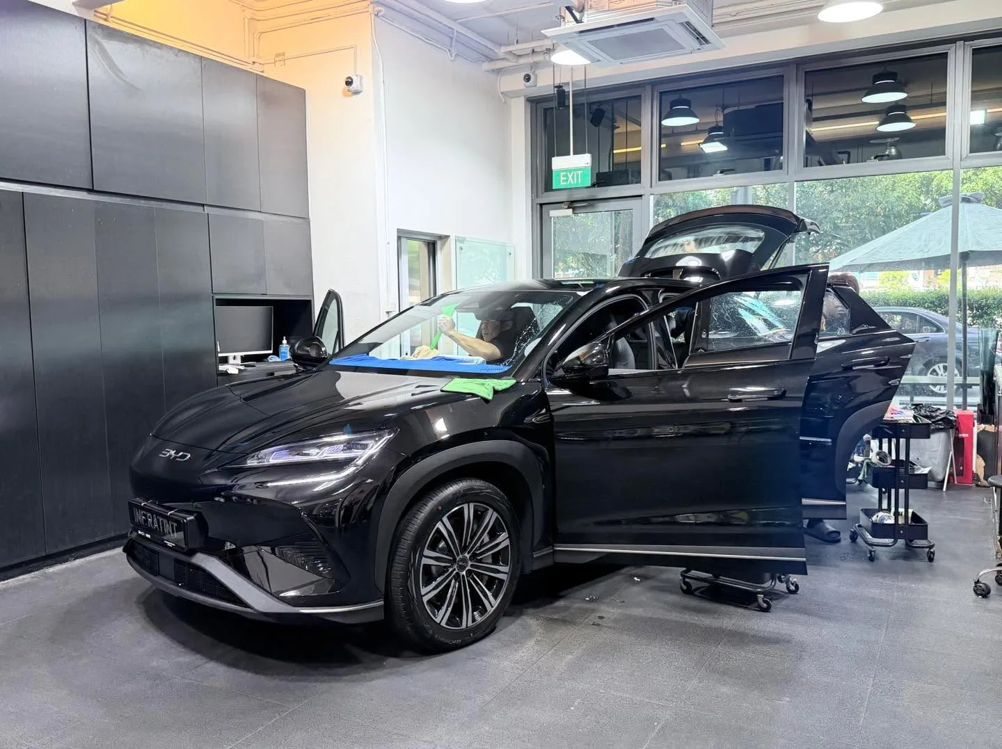 A white Avatr 07 electric sedan parked front-on in the workshop with both doors open.