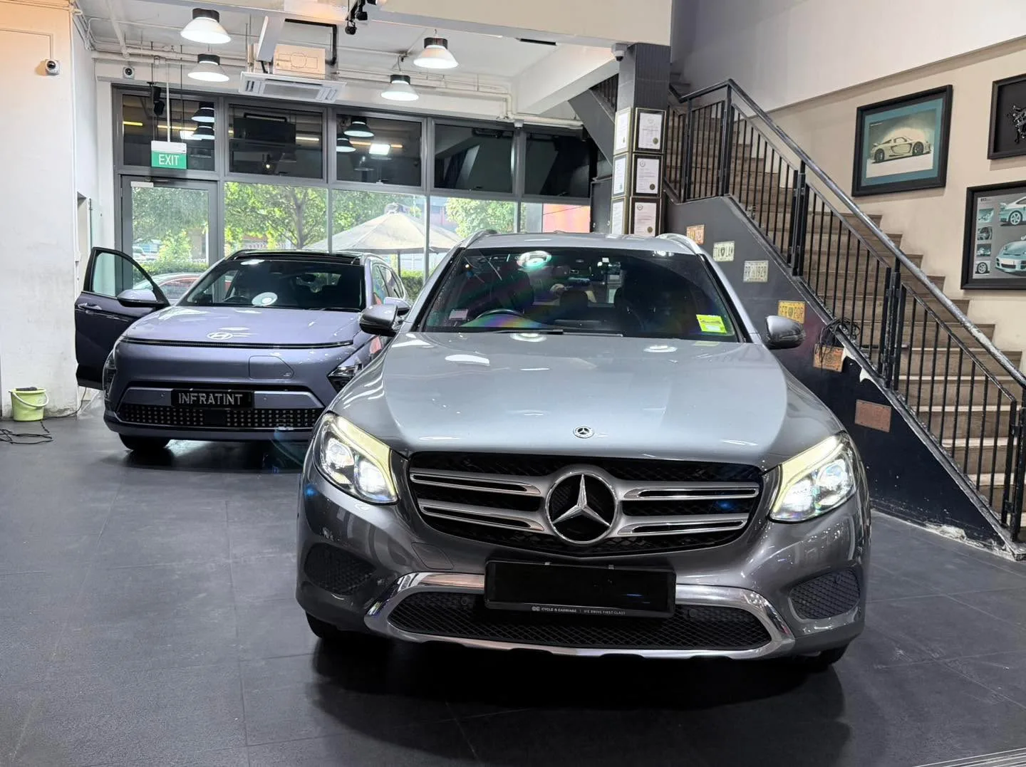 A black Tesla and grey Mercedes saloon parked side by side.