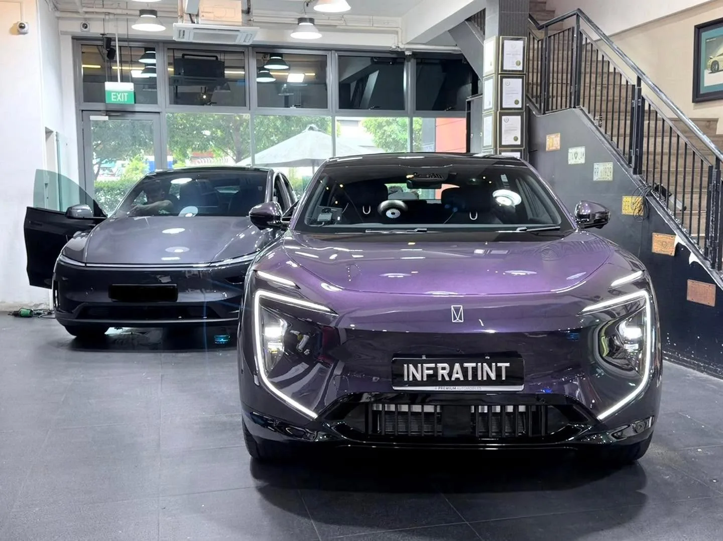 A dark purple AVATR 07 sedan with striking headlights, parked facing the camera indoors.