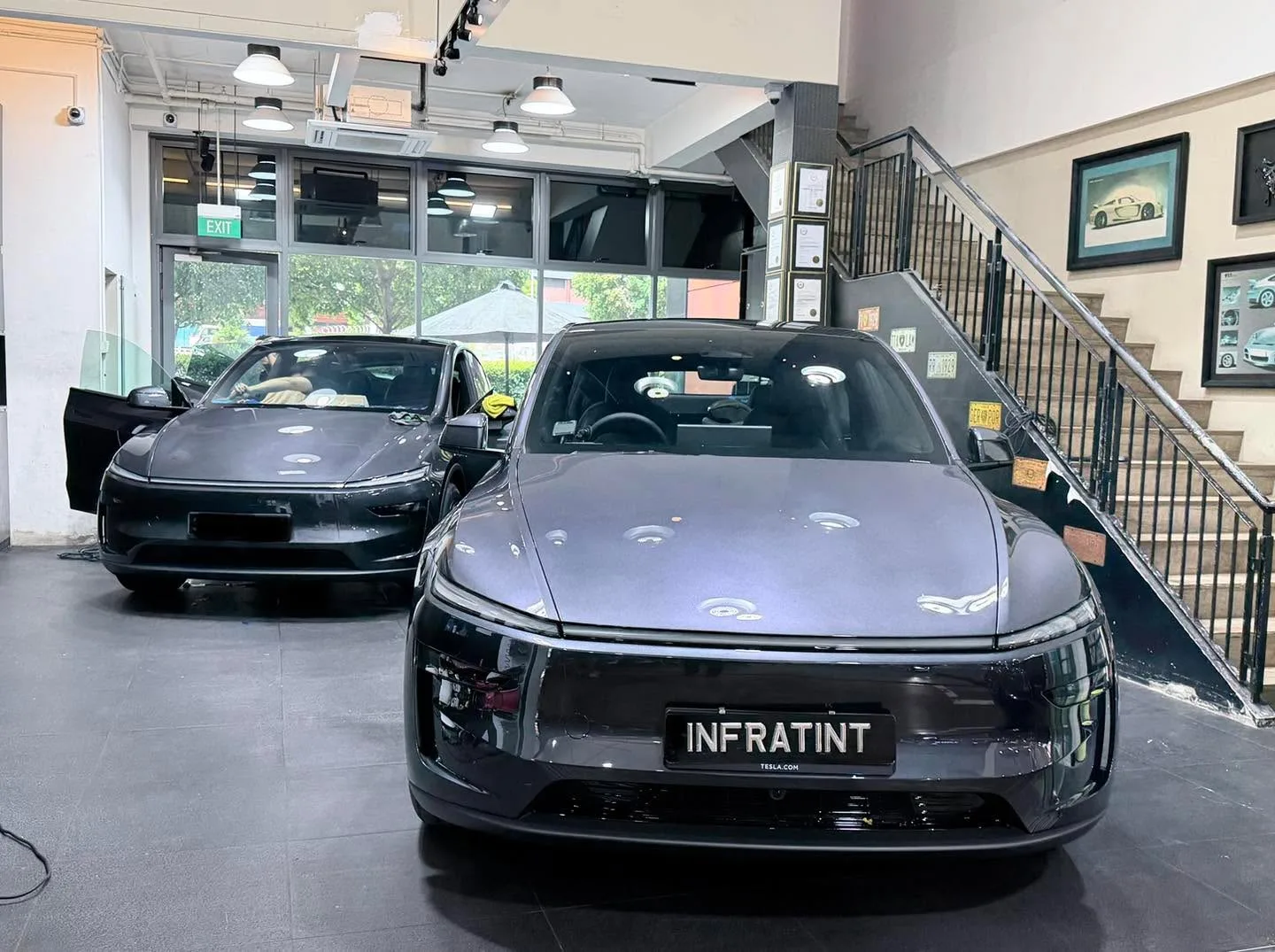 A black Tesla and a dark purple AVATR 07 sedan parked indoors.