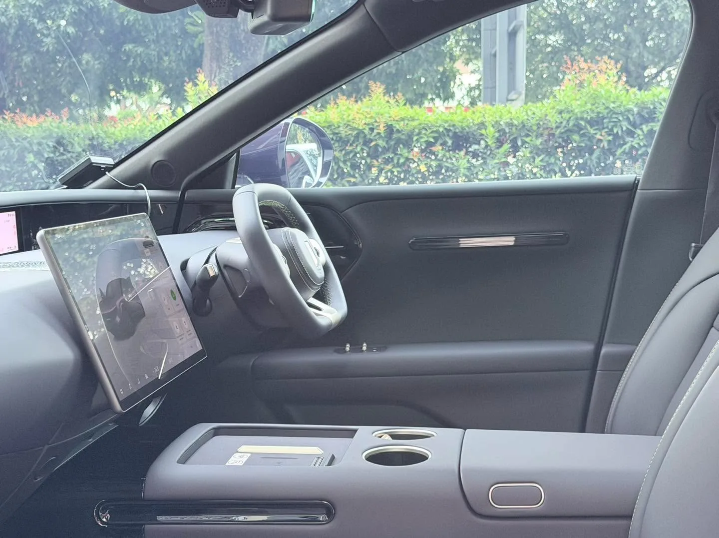 Interior view showing the steering wheel and dashboard with tinted windows visible.