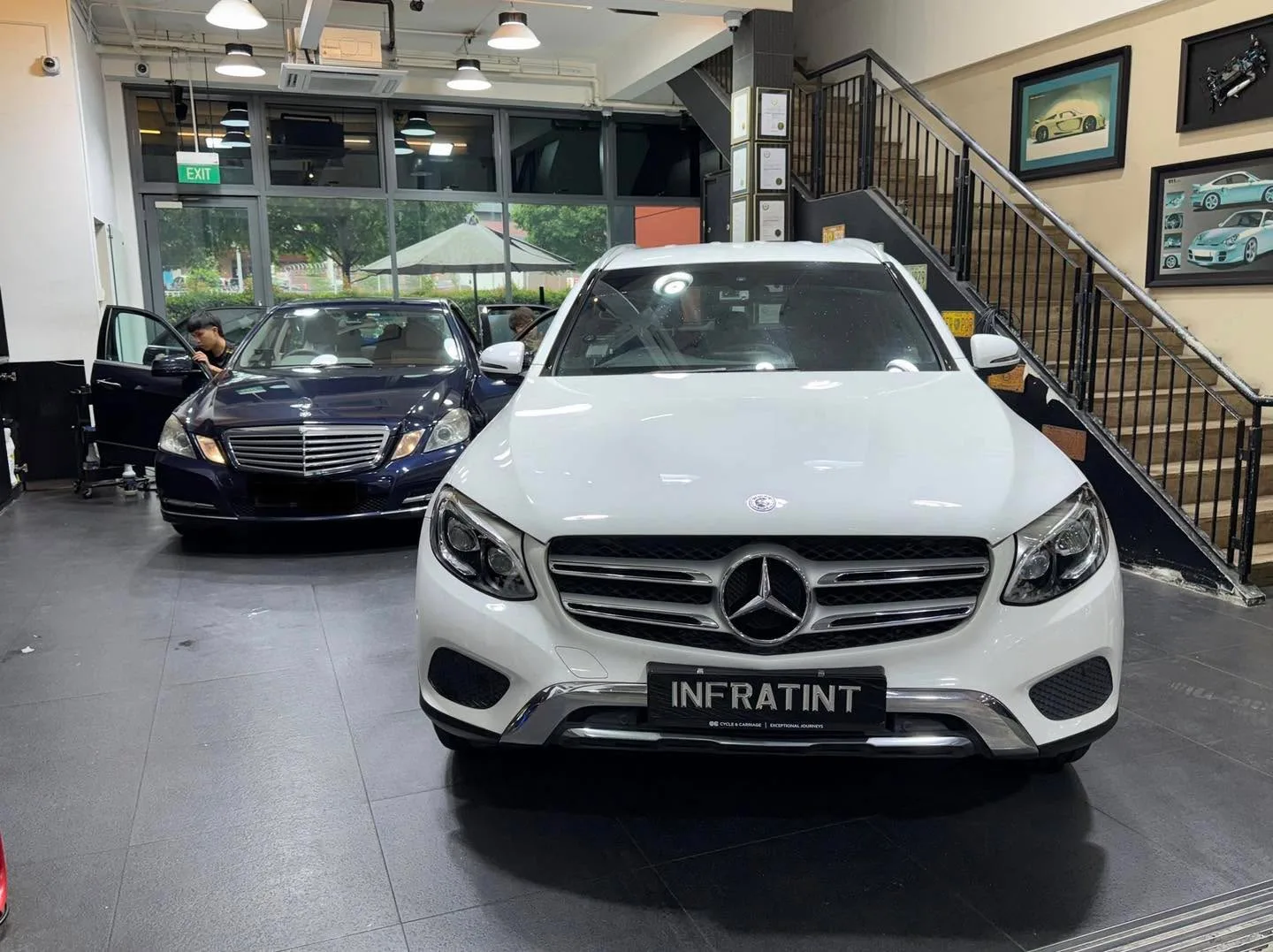 A white Mercedes sedan in the foreground with a white Audi sedan visible behind it.