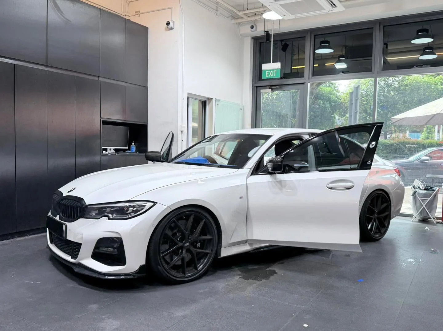 Two white BMW vehicles: an X5 SUV and a 3 Series sedan with doors open.