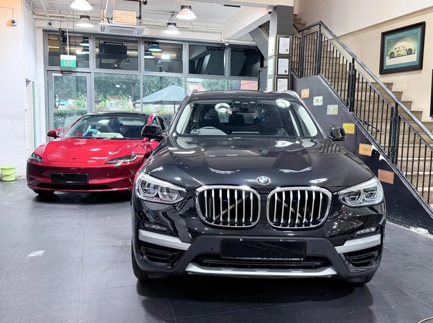 A red sedan and a black SUV with distinctive grille indoors.