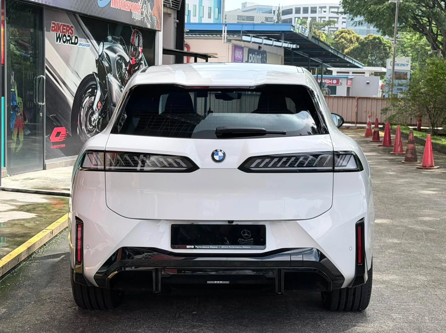A white BMW iX3 M Sport Pro SUV with newly tinted windows, photographed from the rear at the workshop.
