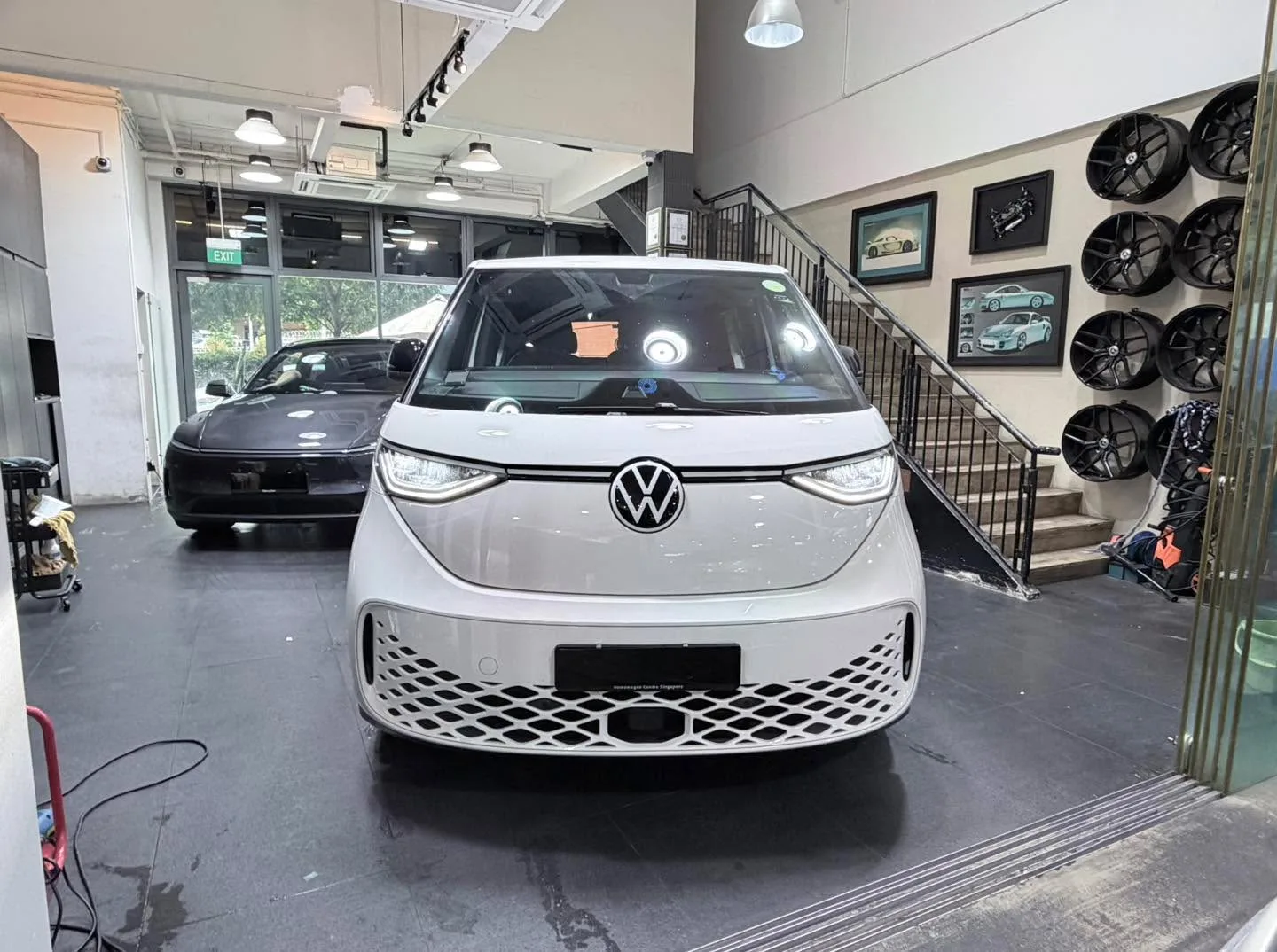 A white Volkswagen ID. Buzz electric van viewed from the front in the workshop.