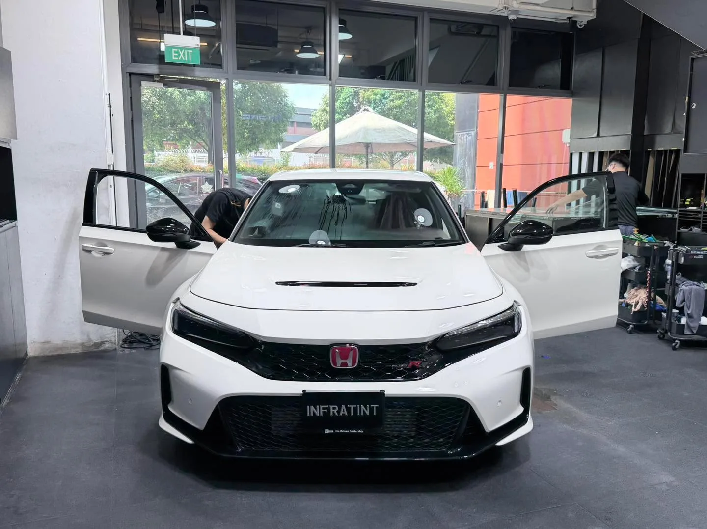 A white hatchback with doors open inside the workshop.