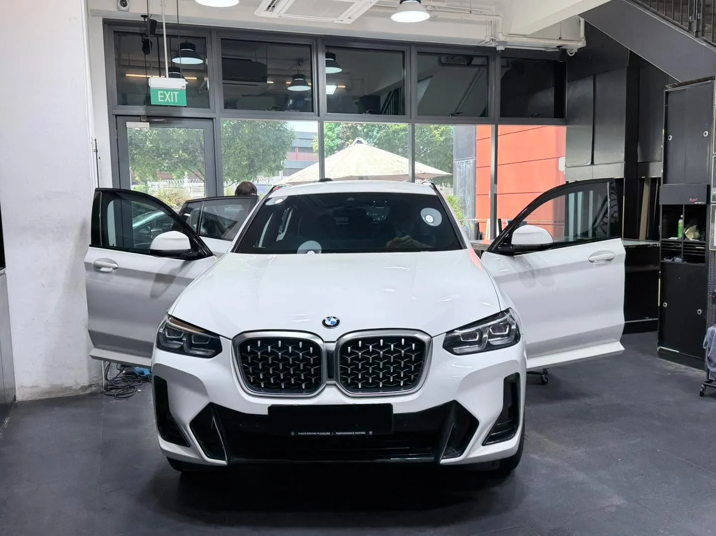 A white BMW X3 SUV with doors open facing forward.
