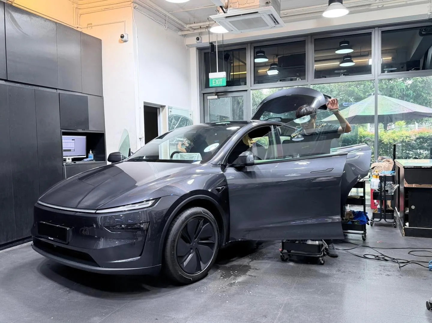 A grey Hyundai Avante sedan with doors open, photographed from the front indoors.
