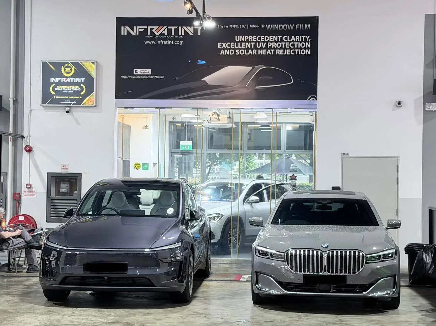 A grey BMW X2 and a white BYD Sealing 7 at the workshop.