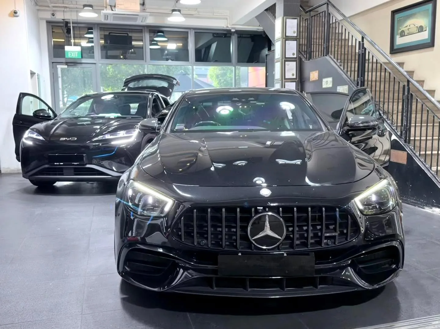 A black Mercedes-Benz with an M badge, photographed head-on in the workshop.
