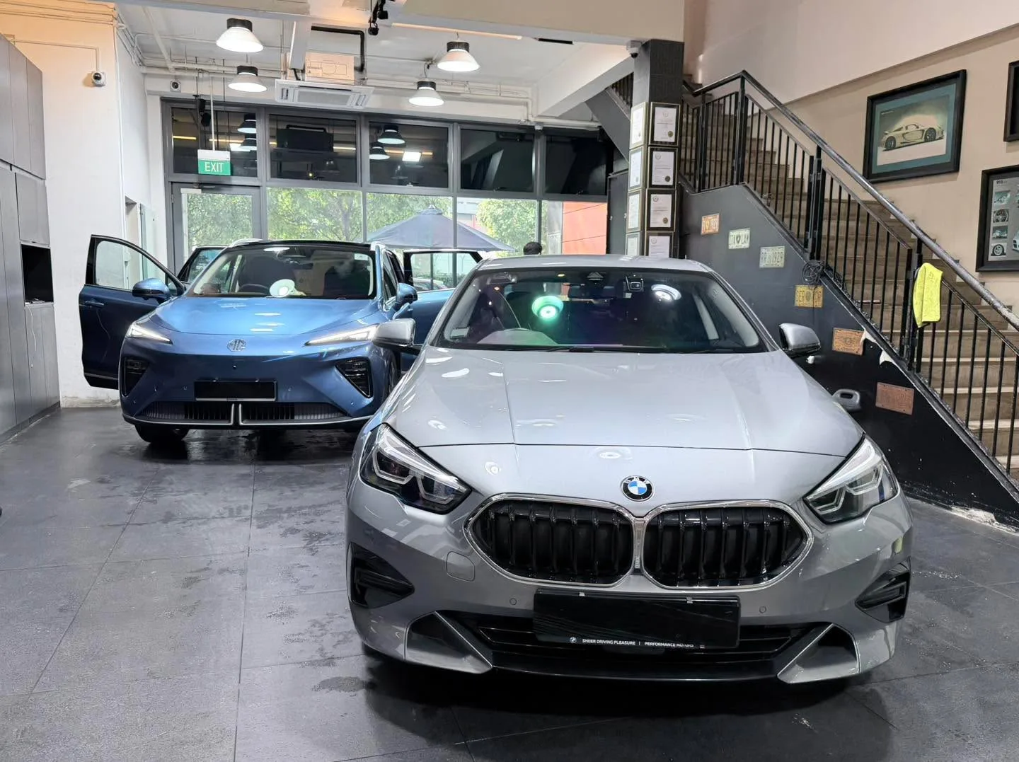 A blue Zeekr 7X and a silver BMW sedan in the workshop.
