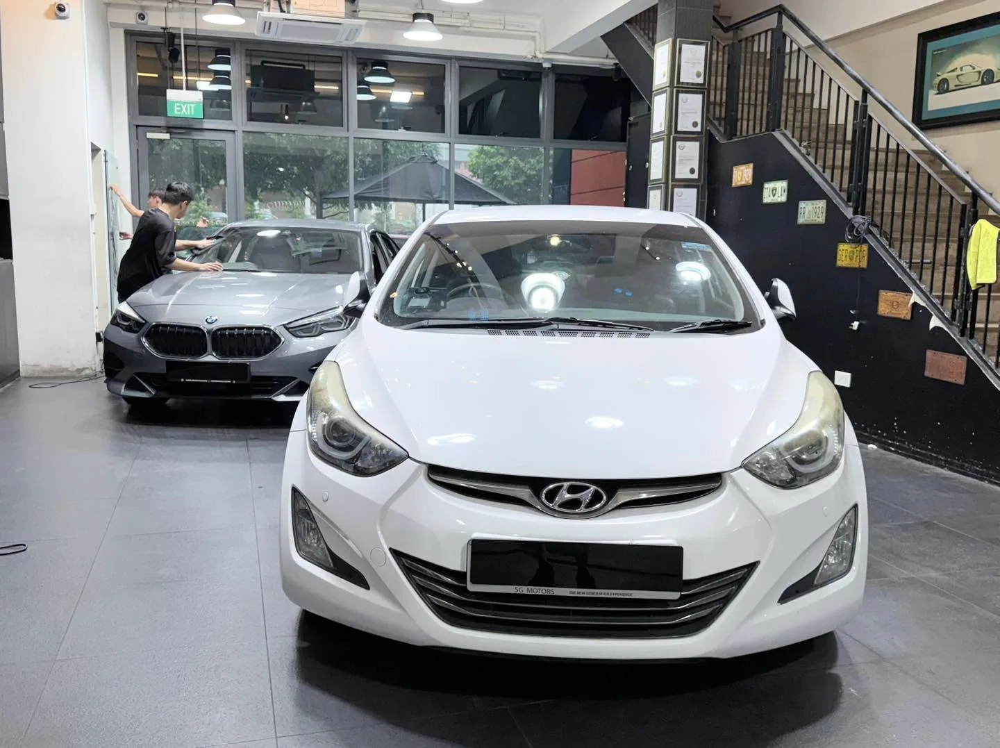 A white MG S6 and a silver BMW sedan inside the workshop.