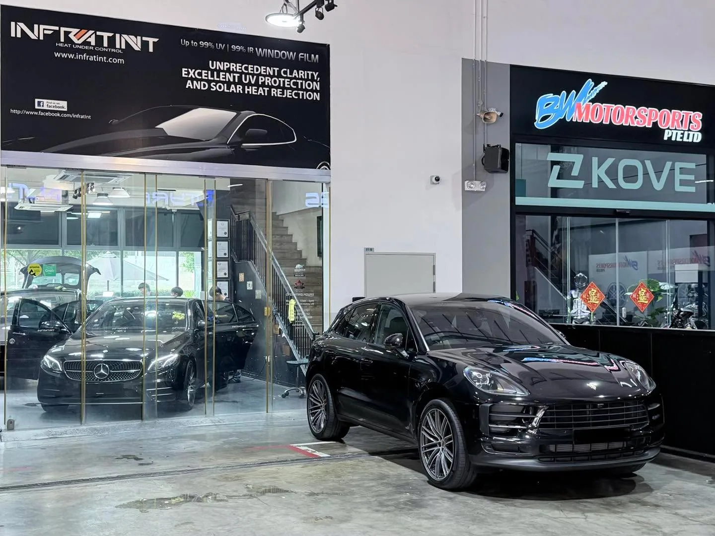Black Porsche Macan SUV parked outside the workshop with Infratint signage visible.