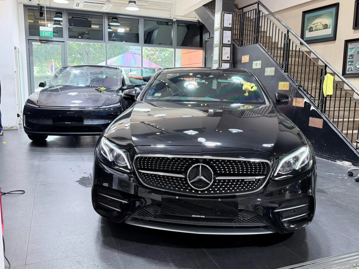 Black Mercedes-Benz sedan with distinctive grille and LED headlights in the workshop.
