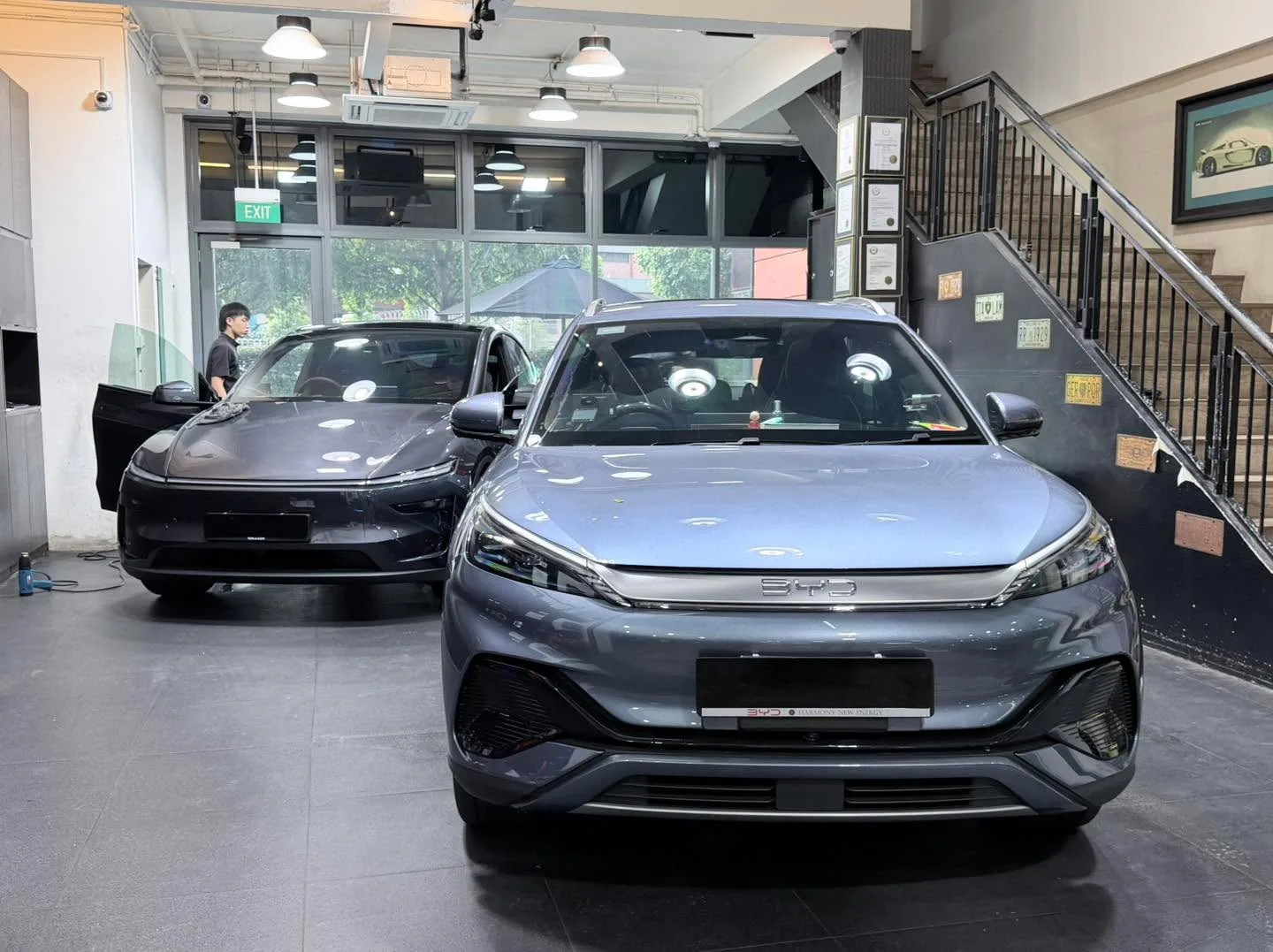 A white Tesla Model Y crossover viewed from the front with tinted windows applied at the workshop.