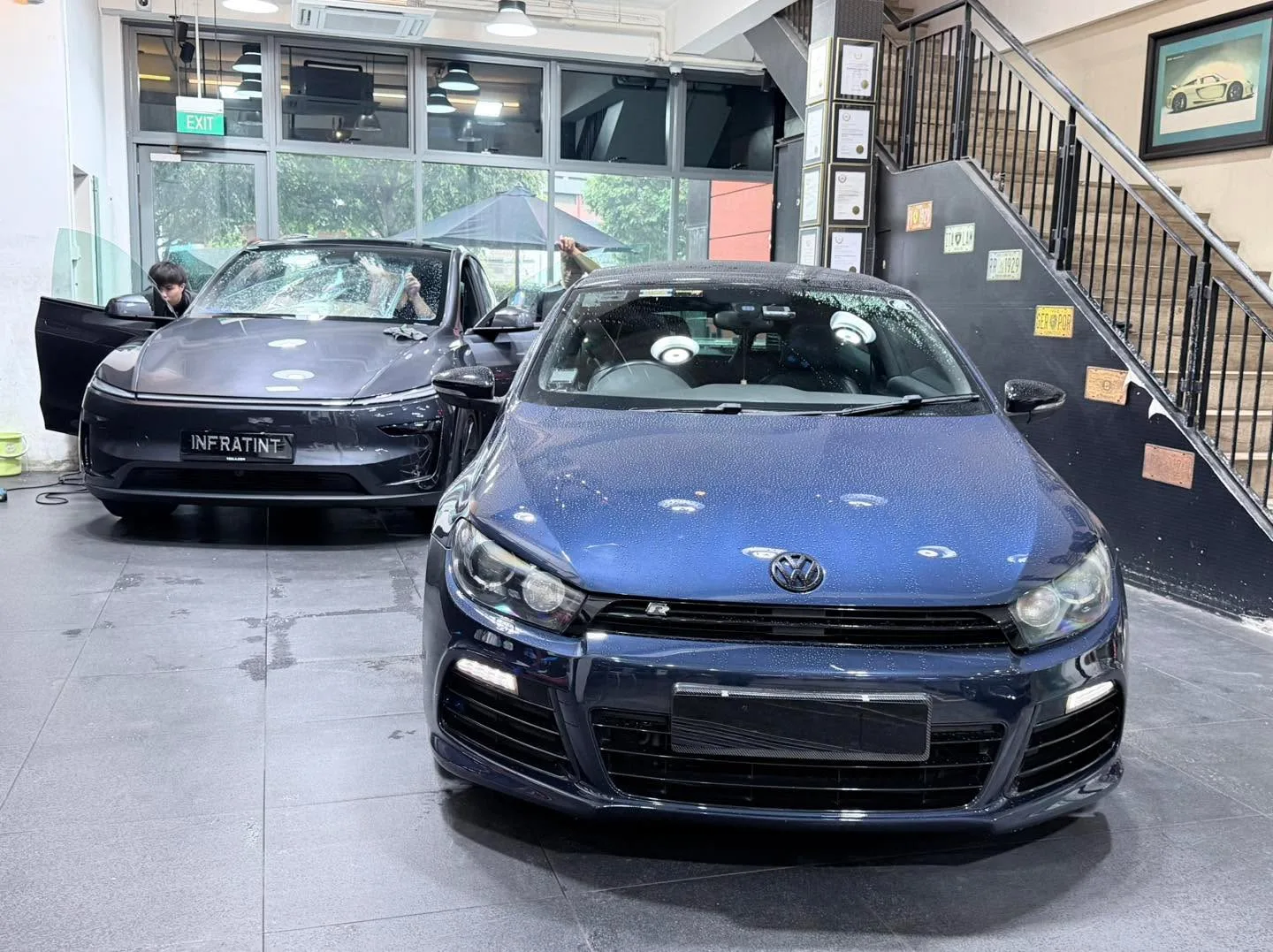 A white Honda Shuttle minivan and a silver Honda Civic saloon with doors open at the workshop.