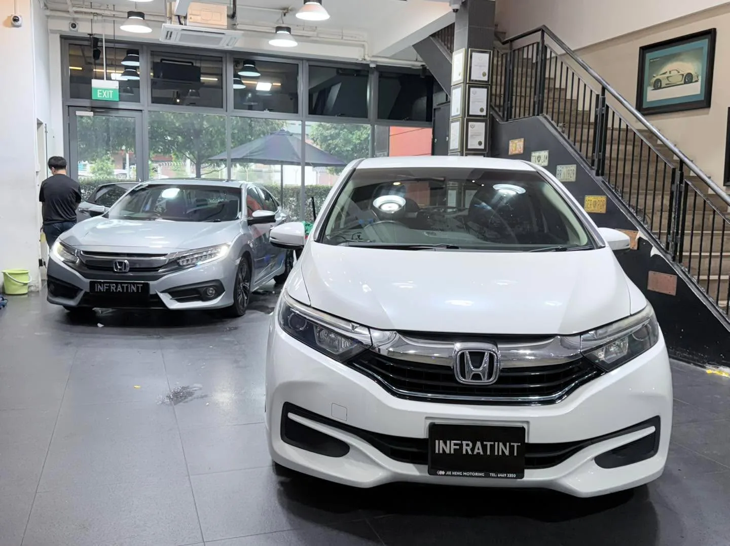 A white Honda Odyssey minivan viewed from the front at the workshop with doors open.