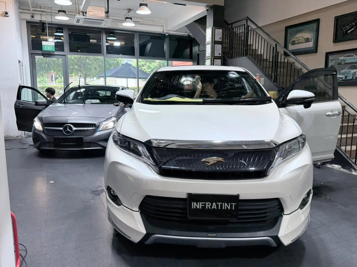 A white Audi e-tron and white MG S6 parked in the workshop, front view of the Audi.