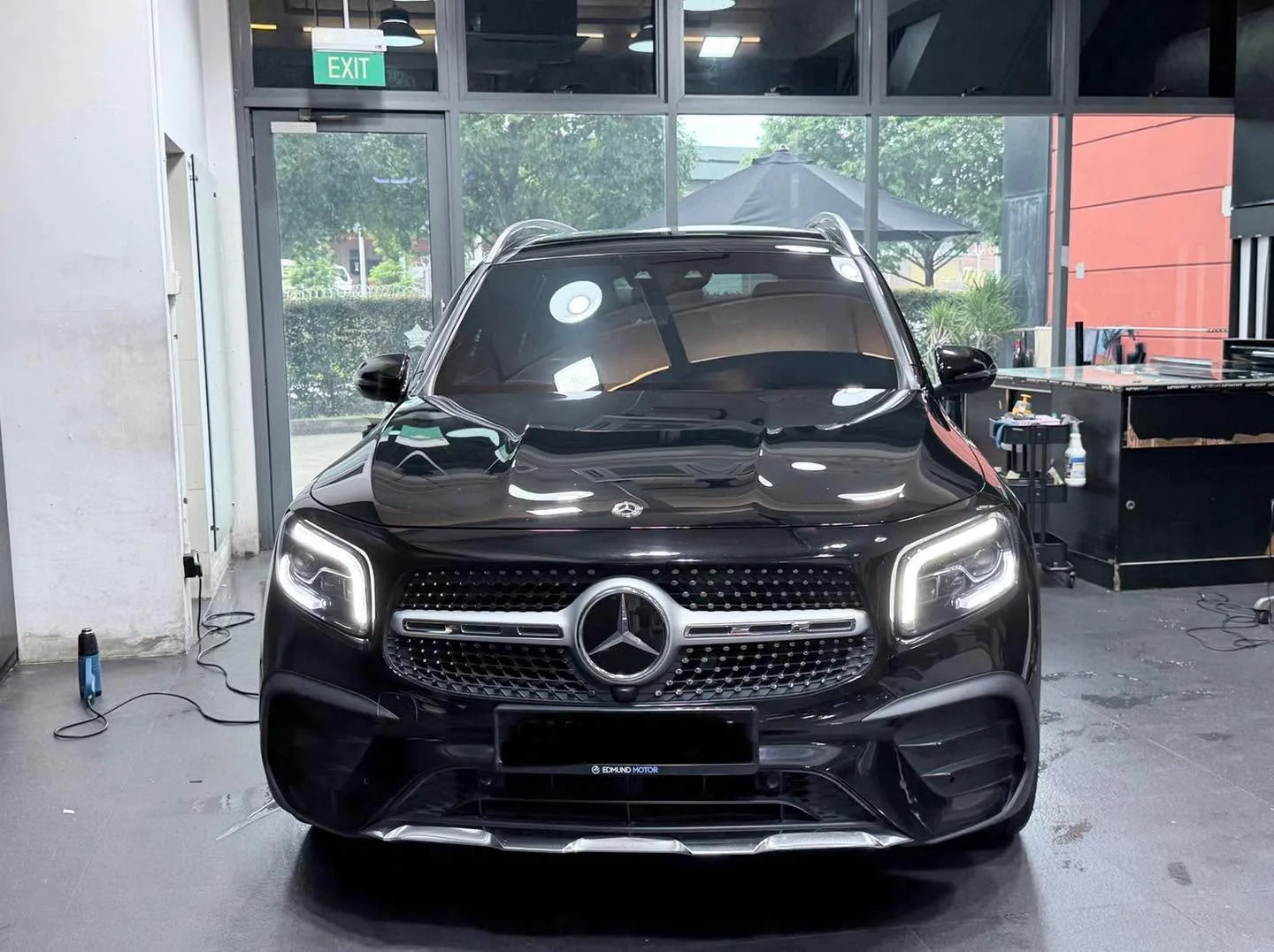 A black Mercedes-Benz compact SUV parked in the workshop.