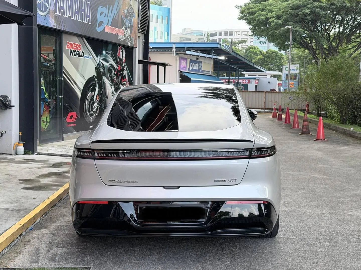 A white Dongfeng 007 sedan photographed from the rear, parked at an external location, displaying the tinted rear windows.