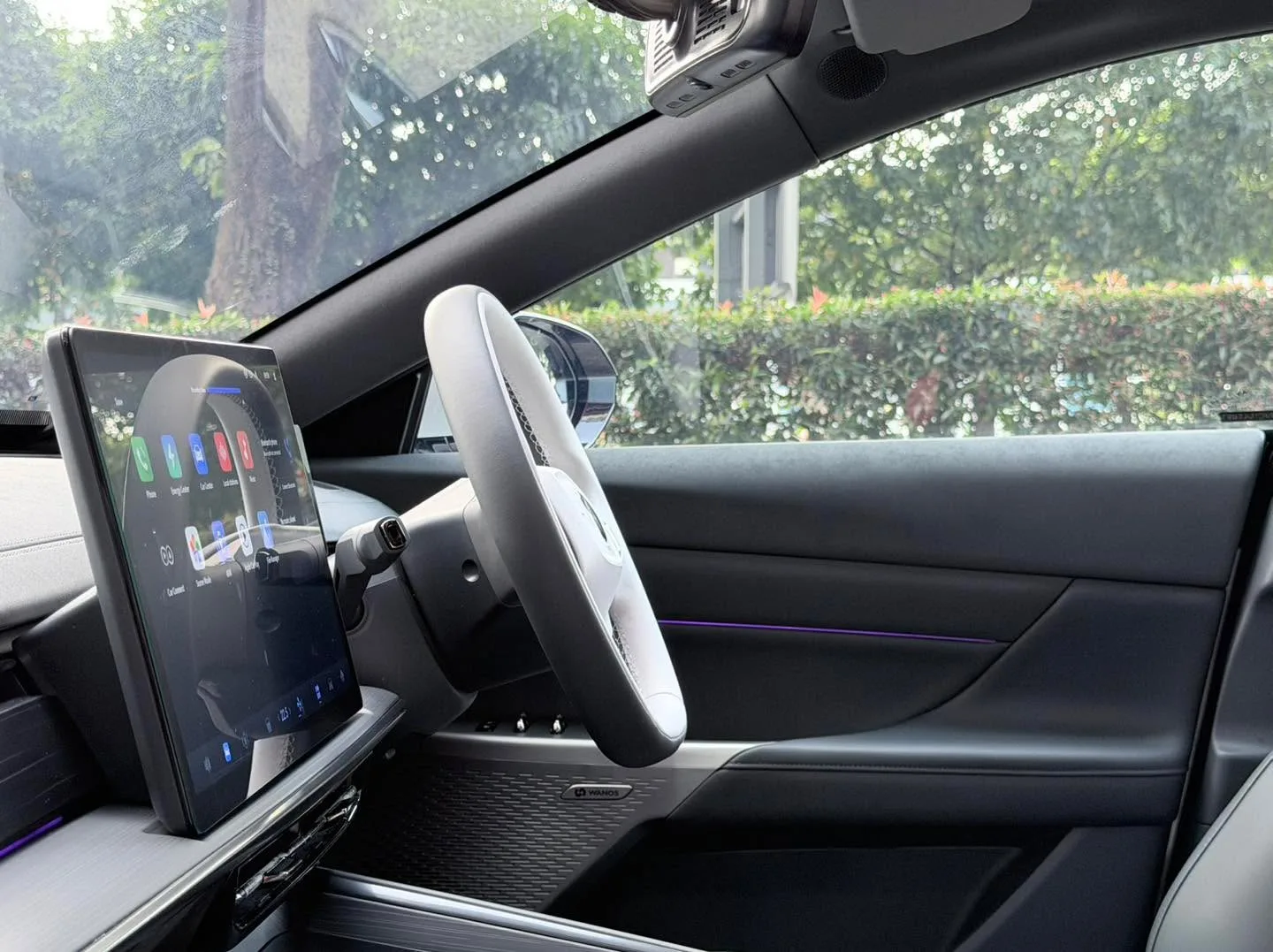 Interior view of a white Dongfeng 007 showing the dashboard, steering wheel and upper windows with tint applied.